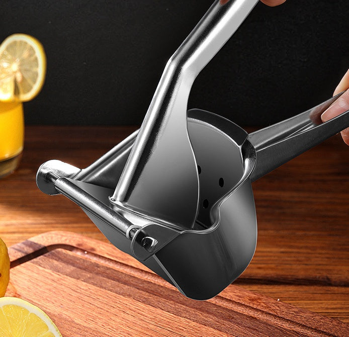 Stainless steel citrus juicer held by hand with cut lemon in bowl