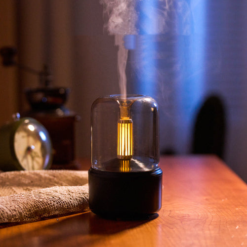 Beige aroma diffuser with flickering light on a dark background
